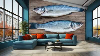 Two raw seabass fish on wooden background Wall mural