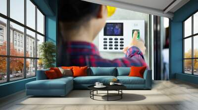 Woman foreman or Architect  scanning her fingerprint on the machine to record working time or access control. Fingerprint scanner for security system in digital technology concept. Wall mural