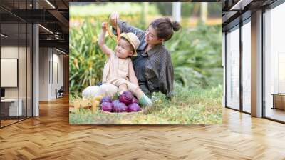 Mother and son toddler boy on organic vegetable farm in summer.Mother with kid Harvesting Organic vegetable potatoes Cabbage on farm at Home school kid learning how to vegetable growth with mother Wall mural