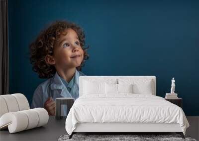 Portrait of a kid dressed in a doctor's white coat and stethoscope. A happy child who is looking thoughtful with a studio background, conceptual of imagination and dream career, free copy space Wall mural