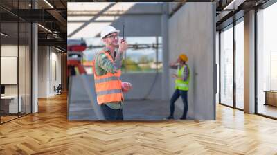 Two professionals inspect construction site of commercial building, industrial building, real estate project  civil engineer, investor using laplet in background crane, skyscraper, concrete formwork Wall mural