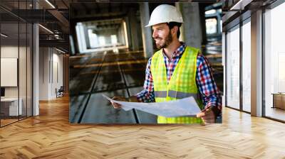 Architect, engineer looking at blueprints in a construction site Wall mural