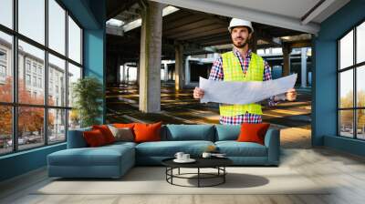 Architect, engineer looking at blueprints in a construction site Wall mural