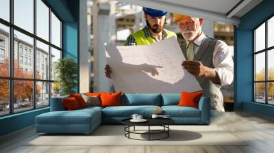 Architect and construction engineer or surveyor discussion plans and blueprints Wall mural