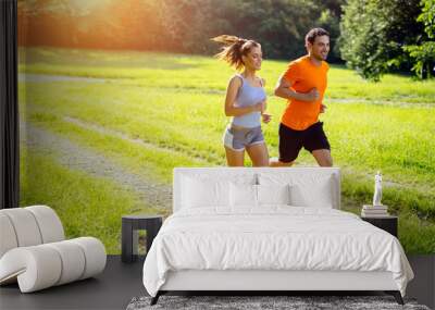 Athletic couple jogging in nature Wall mural