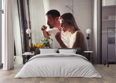 Attractive couple washing teeth in morning together Wall mural