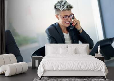 Beautiful businesswoman working sitting at her desk Wall mural