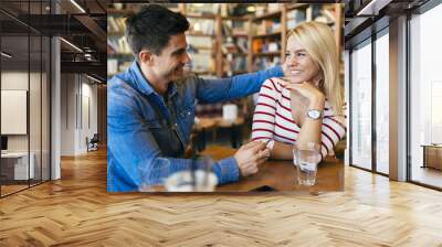 Beautiful couple in love flirting in cafe Wall mural