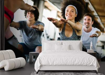 Beautiful fit people exercising together in gym Wall mural