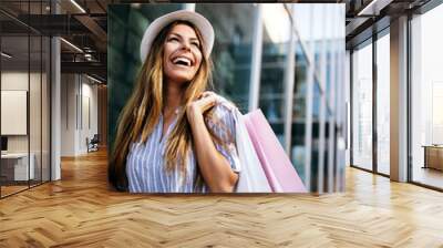 Beautiful woman with shopping bags in the ctiy. Sale, shopping, tourism and happy people concept Wall mural