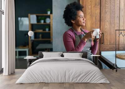 Beautiful young african american woman enjoying a cup of coffee while relaxing Wall mural