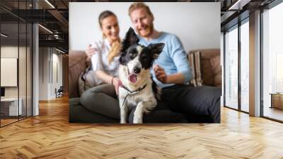 Beautiful young couple relaxing at home and loving their pet Wall mural