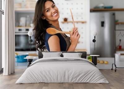 Beautiful young woman cooking at home. Healthy food, people concept Wall mural