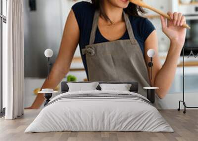 Beautiful young woman cooking in the kitchen. Healthy, organic, food concept Wall mural