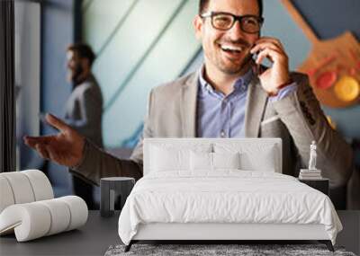 Business, people and office concept. Happy young businessman talking on phone in office Wall mural