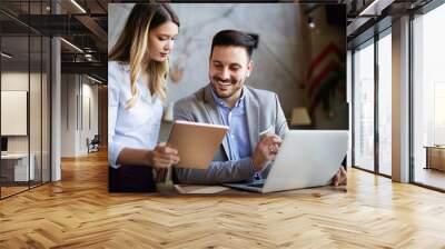 Business colleagues laughing and working while looking at the laptop Wall mural