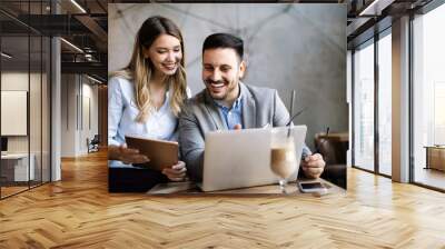 Business colleagues laughing and working while looking at the laptop Wall mural