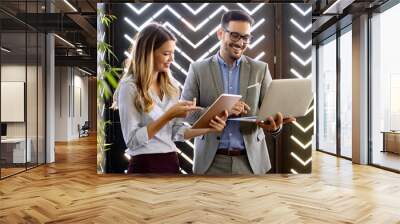 Business colleagues laughing and working while looking at the laptop Wall mural