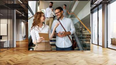 Business people having fun, teamwork and chatting at workplace office together. Wall mural