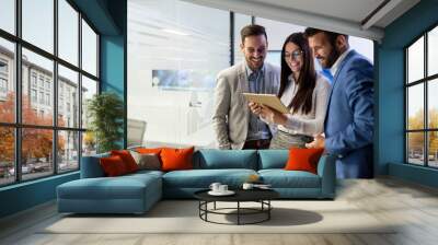 Businessmen and businesswoman using tablet in office Wall mural