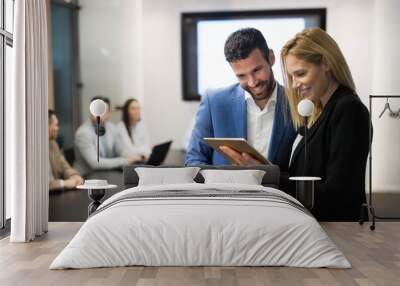 Businesspeople discussing while using digital tablet in office Wall mural