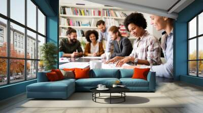 Cheerful coworkers in office during company meeting Wall mural