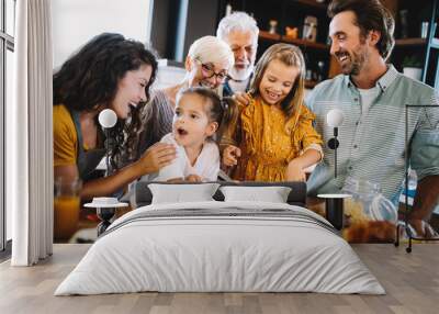 Cheerful family spending good time together while cooking in kitchen Wall mural