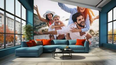 Cheerful friends enjoying weekend and having fun on beach Wall mural