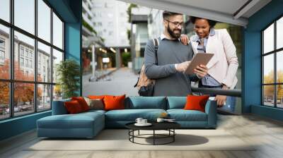 Cheerful people having fun, talking with electronic tablet in city outdoor Wall mural