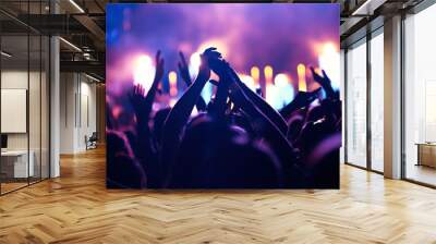 Cheering crowd with hands in air at music festival Wall mural