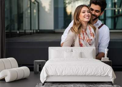 Close up of a smiling beautiful young couple embracing while standing outdoors. Wall mural