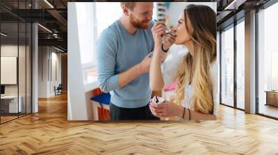 Couple having fun and laughing at home while eating ice cream Wall mural