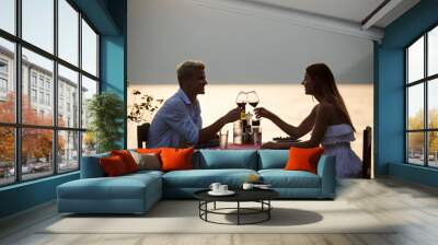 Couple sharing romantic sunset dinner on tropical resort Wall mural