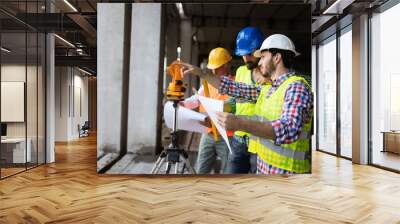 Engineer, foreman and worker discussing in building construction site Wall mural