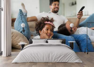 Family watches movie while sitting on the couch Wall mural