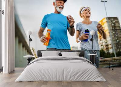 Fitness, sport, people, exercising and lifestyle concept - senior couple running Wall mural