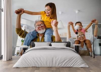 Grandchildren having fun at home while playing with their grandparents Wall mural