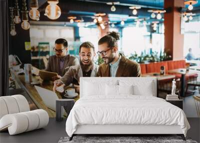 Group of attractive young business men colleagues working together in cafe Wall mural