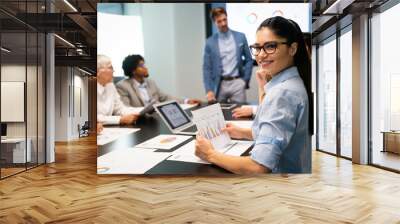 Group of business partners discussing documents and ideas at meeting Wall mural