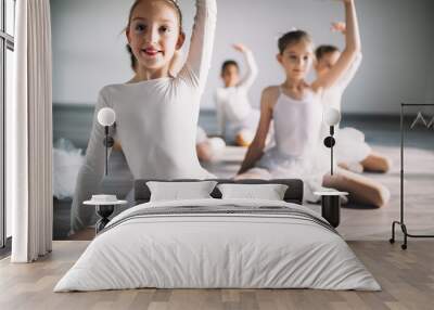 Group of fit happy children exercising ballet in studio together Wall mural