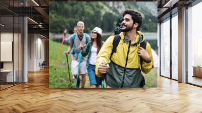 Group of friends hiking together outdoors exploring the wilderness and having fun Wall mural