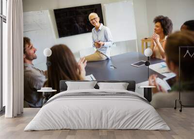 Group of happy business people discussing and working together during a meeting in office Wall mural