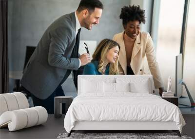 Group of happy multiethnic business people in formal wear gathered around computer in office Wall mural