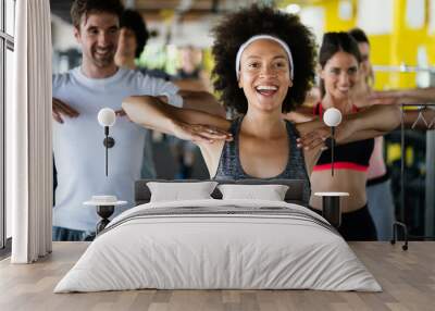 Group of happy multiracial friends exercising together in gym Wall mural