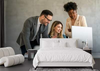 Group of multiethnic business people analyzing data using computer while working in the office Wall mural