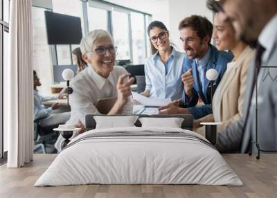 Group of young business people working and communicating at the office Wall mural