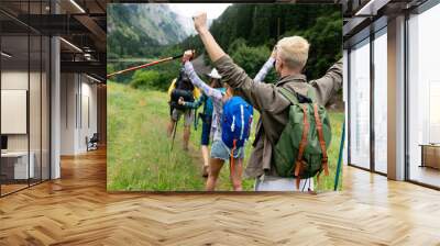 Group of young friends hiking in countryside. Multiracial happy people travelling Wall mural