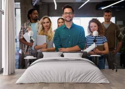 Group of young multi-ethnic startup business team collaborating on project in modern office Wall mural