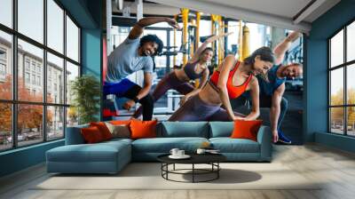 Group of young people doing exercises in gym Wall mural