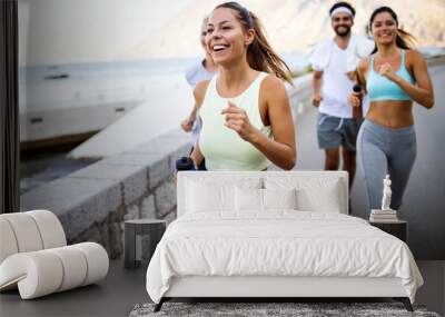 Group of young people friends running outdoors at seaside Wall mural